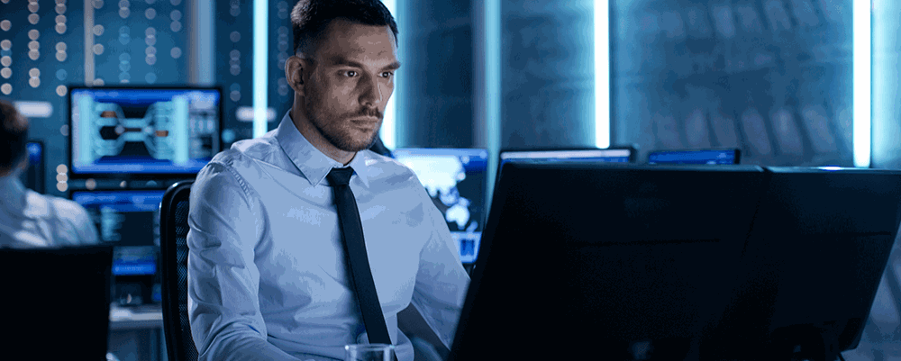 Professional man in front of computer in control room