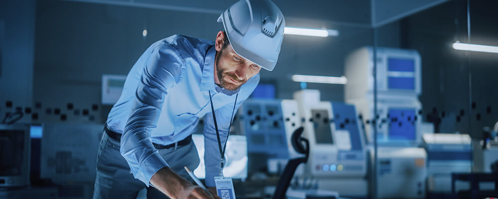 male-engineer_in_hardhat_using_pen_on_touchscreen_digital_table